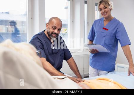 Nurses talking to patient on hospital bed Stock Photo