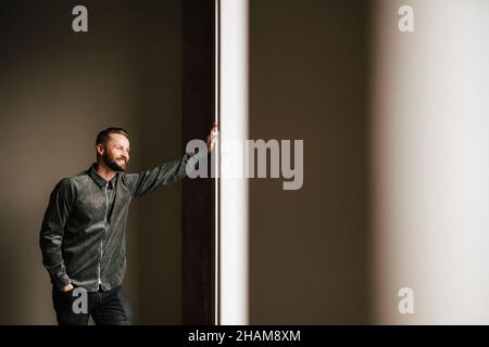 Man looking through window Stock Photo