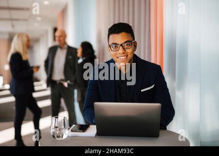 Man with laptop sitting in office Stock Photo