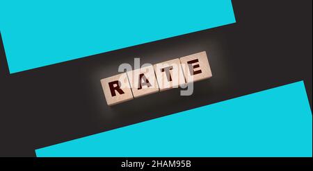 Rate word concept written on wooden cubes blocks lying on a black background. Business services rating concept. Stock Photo