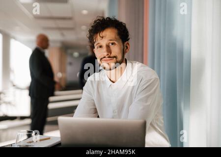 Man with laptop sitting in office Stock Photo