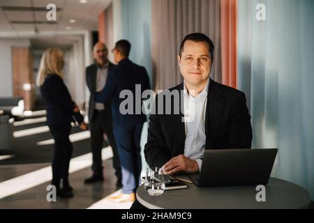 Man with laptop sitting in office Stock Photo