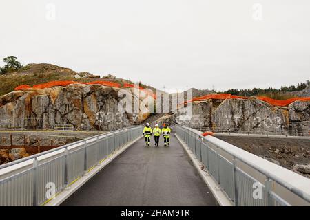 Engineers in reflective clothing walking on bridge Stock Photo