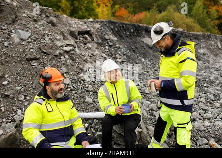 Engineers in reflective clothing having hot drink Stock Photo
