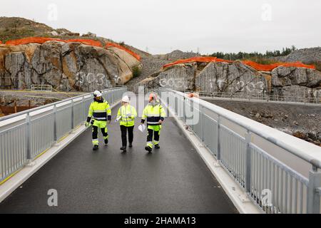 Engineers in reflective clothing walking on bridge Stock Photo