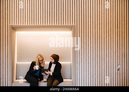 Female coworkers talking together Stock Photo