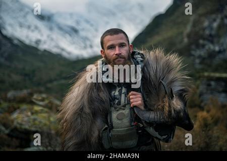 Hunter in mountains looking at camera Stock Photo