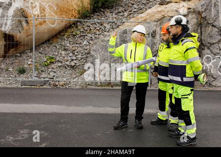 Engineers in reflective clothing discussing plans Stock Photo