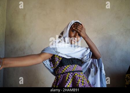 Gorgeous Mali African girl Portrait. Beautiful black teenage woman with hand on forehead with rough wall background Stock Photo