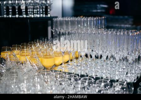 transparent glasses and glasses with juice lined up and ready to receive guests Stock Photo