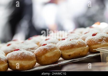 fried and stuffed sufganiot with strawberry jam, displayed for sale at the Mahane Yehuda market in Jerusalem, Hanukkah Stock Photo