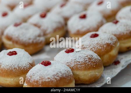 fried and stuffed sufganiot with strawberry jam, displayed for sale at the Mahane Yehuda market in Jerusalem, Hanukkah Stock Photo