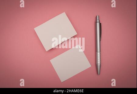 blank business card on pink background with a pen Stock Photo