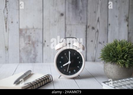 alarm clock ,notepad and pen on table  Stock Photo