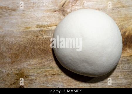 Ball of pizza dough on a rustic wooden background Stock Photo