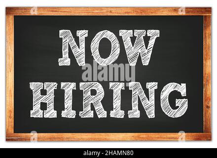 NOW HIRING written on black wooden frame school blackboard Stock Photo