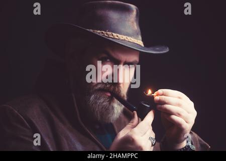 Bearded man smoking tradition pipe. Fashion portrait. Stock Photo