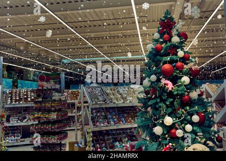 Beautiful Christmas tree decorated with colorful ball, New Year's decorations on the shelves in the supermarket Epidcenter in Odessa Ukraine Stock Photo