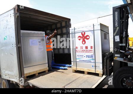 Maputo, Mozambique. 12th Dec, 2021. A staff member transfers the new batch of COVID-19 Sinopharm vaccines donated by China at the Maputo International Airport in Maputo, Mozambique, Dec. 12, 2021. Another batch of COVID-19 Sinopharm vaccines donated by China has arrived in Mozambique to help the African country better deal with the pandemic. Credit: Nie Zuguo/Xinhua/Alamy Live News Stock Photo