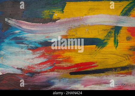 colored spots of paint on a wooden textured board, yellow green bloom paint texture, chaotic strokes of paint Stock Photo