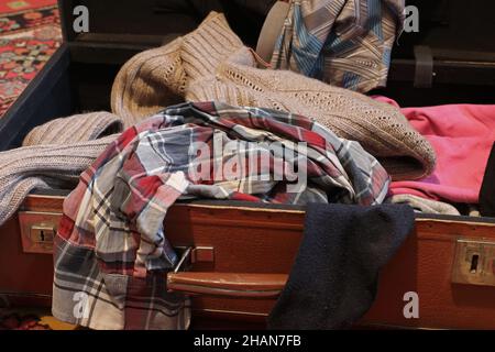 Open old suitcase with clothes Stock Photo