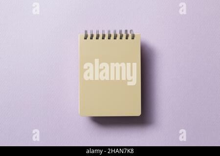 Beige notepad isolated on purple background. top view, copy space Stock Photo