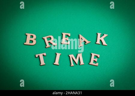 Break time word written with wood letters. break time text on green background Stock Photo