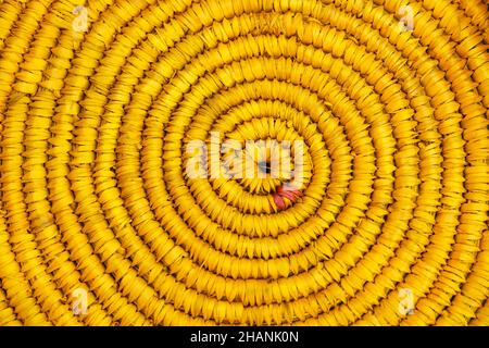 Jute knitted fabric, Handmade: jute and crochet hooks, a circle of jute is tied, close-up, Yellow background, texture. Stock Photo