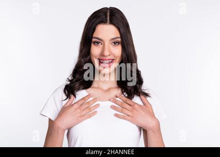 Photo of sweet impressed young woman dressed casual clothes arms chest smiling isolated white color background Stock Photo