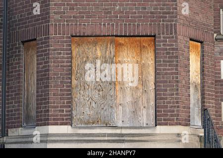 old abandoned apartment building with boarded up windows Stock Photo