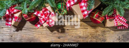 Christmas background with hand crafted gift boxes, fir tree branches and Christmas tree ball, wooden background copy space Stock Photo