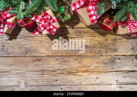 Christmas background with hand crafted gift boxes, fir tree branches and Christmas tree ball, wooden background copy space Stock Photo