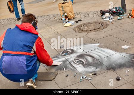 A street artist paints a realistic portrait on the floor of a city square. Street art. Berlin, Germany - 05.17.2019 Stock Photo