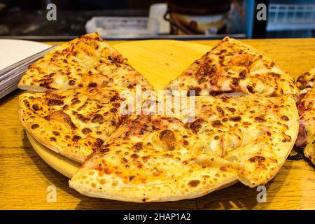 Traditional Italian pizza with prosciutto, mzozarella cheese and olives displayed for sale at a street food market festival in Bucharest, Romania, hea Stock Photo