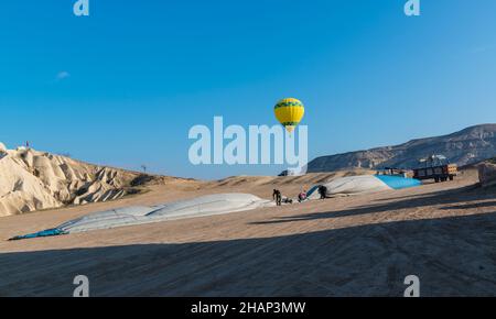 Ground crew members folding a hot air balloon after landing. Cappadocia,  Central Anatolia, Turkey Stock Photo