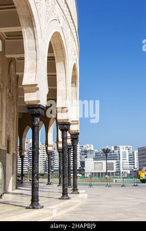 Casablanca, Morocco - February, 21. 2019: Hassan II Mosque pillars surrounded by modern residential buildings in Casablanca, Morocco, which forms a co Stock Photo