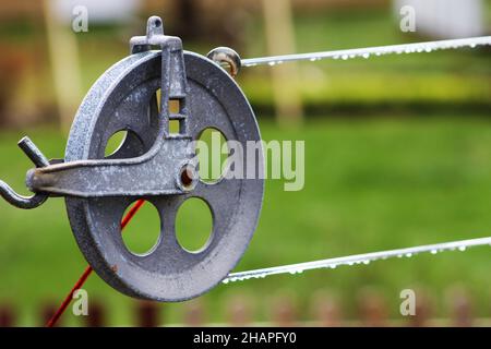 Close-up of a clothesline pulley, drops of rainwater on clothesline. Stock Photo