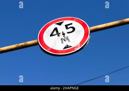 Vehicle height limitation, road sign in front of a low bridge span Stock Photo