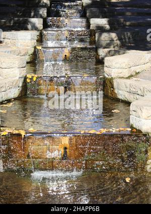 small artificial waterfall made on the stone steps Stock Photo