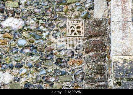 Carved stone monogram with coronette above set in to a wall of the Church of St Mary of the Assumption, Ufford, Suffolk Stock Photo