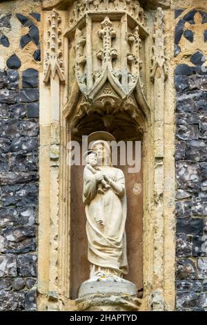 Mary one of the niche statues over the doorway in the porch of St Mary of the Assumption, Ufford, Sussex Stock Photo