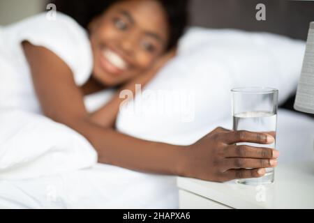 Selective focus on glass of water at bedside Stock Photo