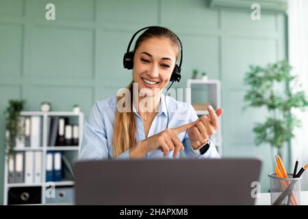 Online education. Young female teacher having video conference chat with students, talking to webcam and explaining Stock Photo