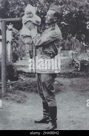 Red Army soldier holding a baby depicted in the black and white vintage photograph by an unknown photographer dated probably from 1945 and taken probably in Czechoslovakia. Stock Photo