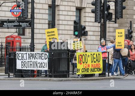 Westminster, London, UK. 14th Dec, 2021. A group of anti vaccination protesters have put up banners and hold placards protesting against continued vaccination efforts and alleged negative effects of covid vaccines near Parliament in Westminster today. Credit: Imageplotter/Alamy Live News Stock Photo