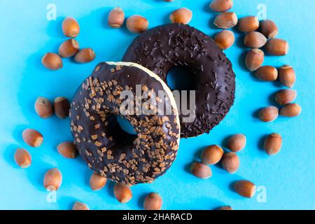 Donut with hazelnuts on a blue background, close up Stock Photo