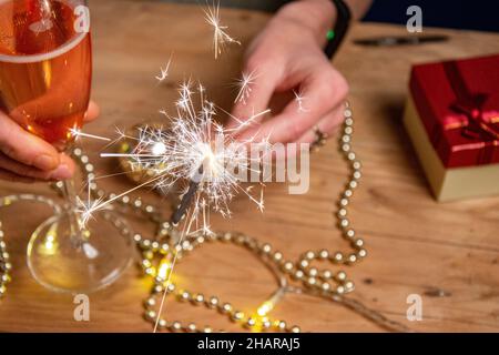 Champagne in hand against the background of the Christmas tree. Happy New year 2022. Stock Photo