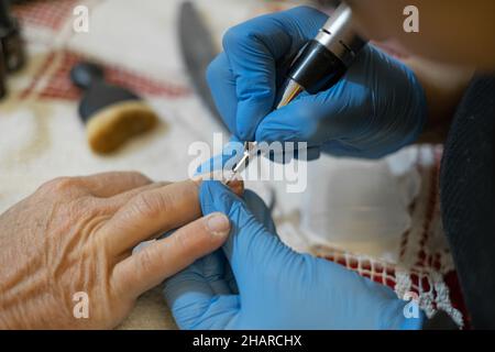 Professional beautician while making onychomycosis treatment and nail reconstruction to a customer,health care therapy Stock Photo