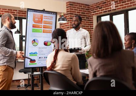 Diverse entrepreneurs analyzing financial statistics working at business presentation during startup company office. Businesspeople brainstorming ideas for management project discussing partnership Stock Photo