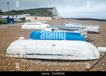 Abandoned,not,used,fishing,rowing,boat,on,empty,Seaford,Beach,shore,English Channel,Seaford Beach,on,a,wet,Summer,August,day,East,Sussex,England,English,weather, Stock Photo